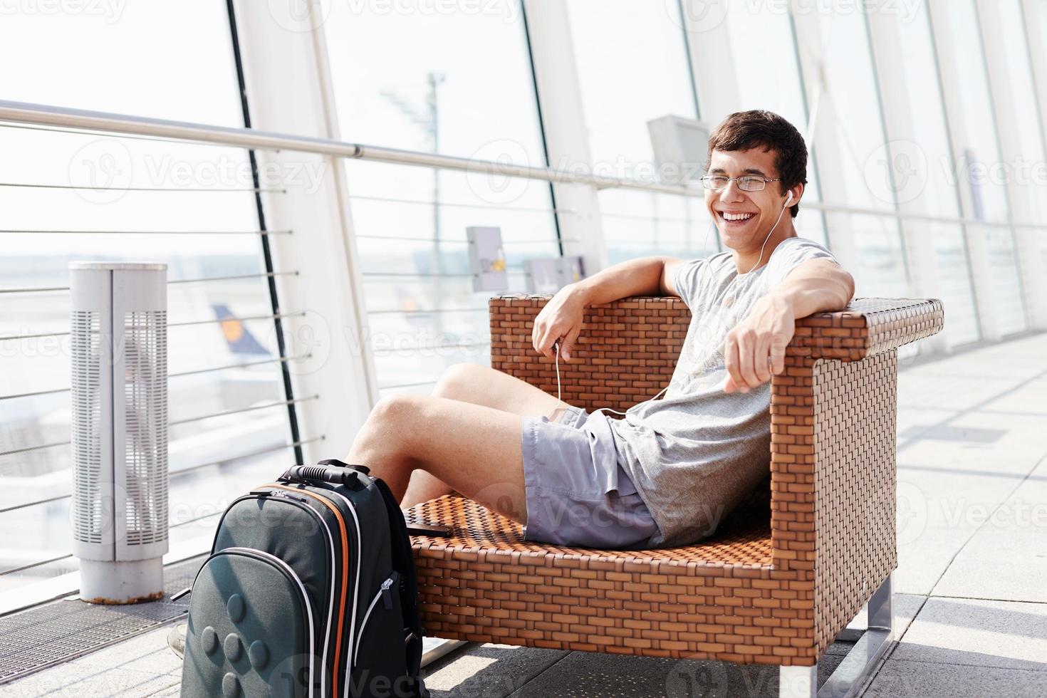 Smiling man waiting for flight at airport photo