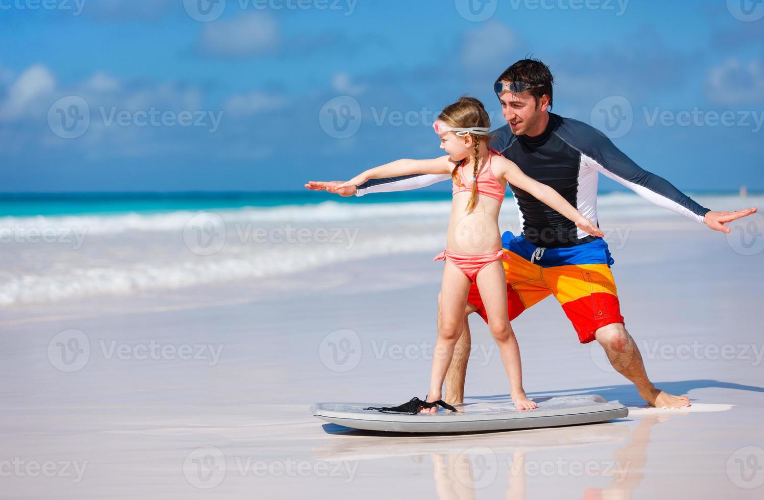 padre e hija practicando surf foto