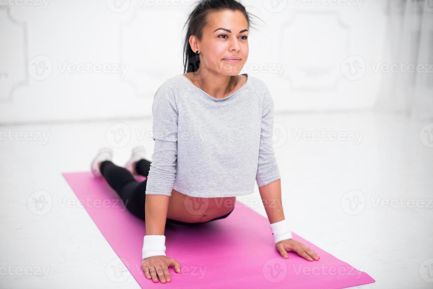 Chica haciendo ejercicio de calentamiento para la columna vertebral, curvatura hacia atrás, arqueando estiramiento foto