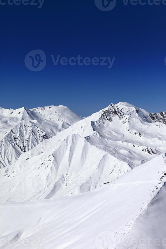 Off-piste slope and blue clear sky in sun day photo