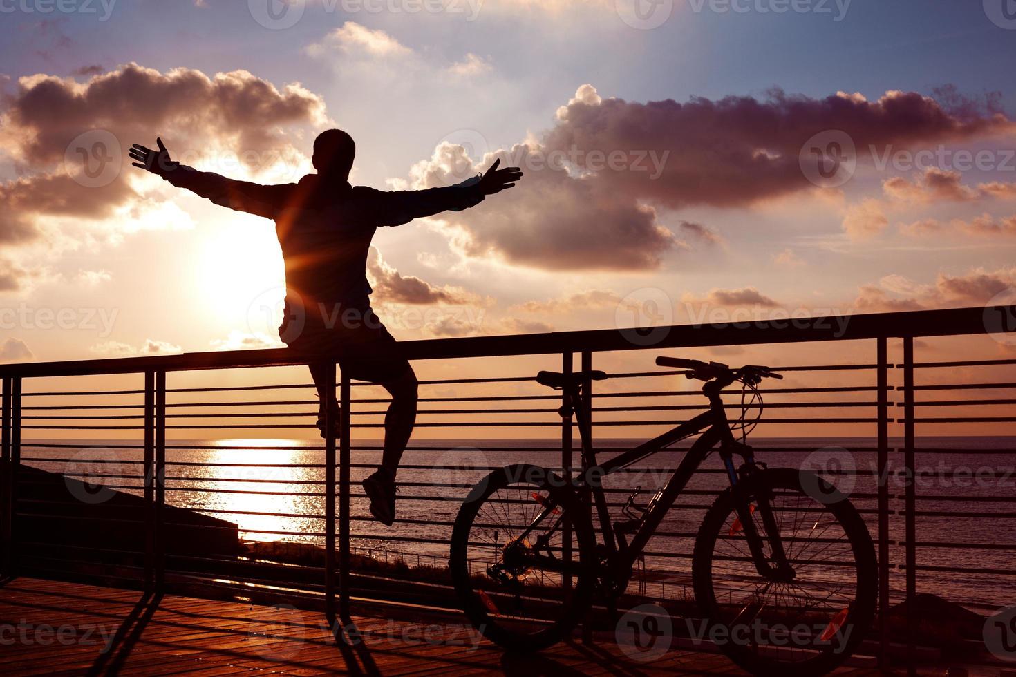 silueta de deportista y bicicleta de montaña al atardecer foto