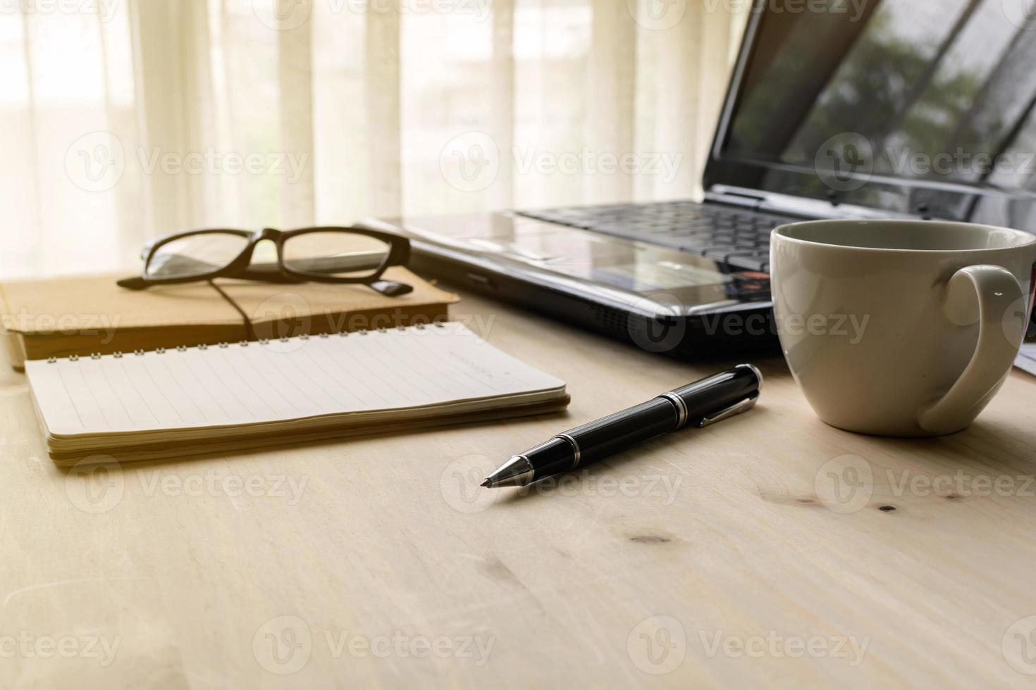 Cup of coffee with laptop on wooden desk and document photo