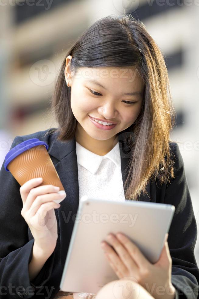 joven ejecutivo de negocios asiático femenino usando tableta foto