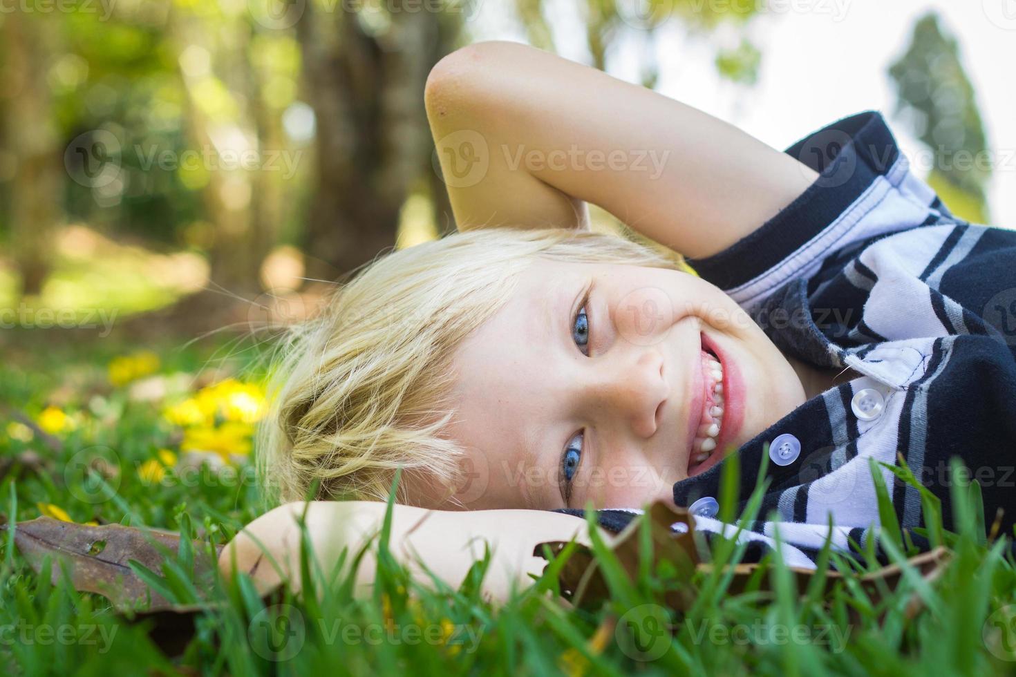 niño feliz tirado en el pasto foto