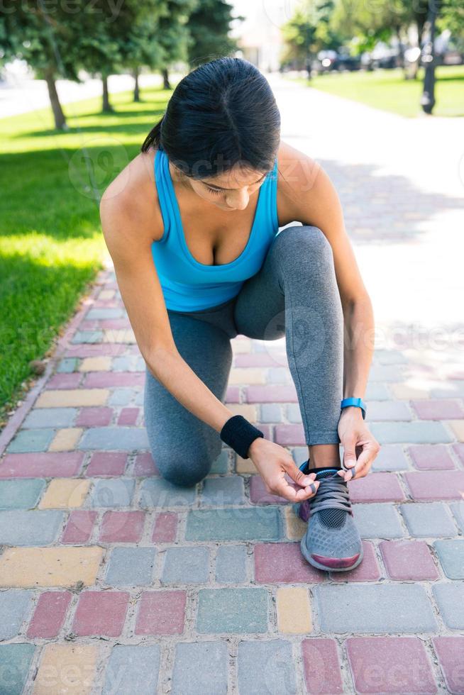 Woman tying her shoelace outdoors photo