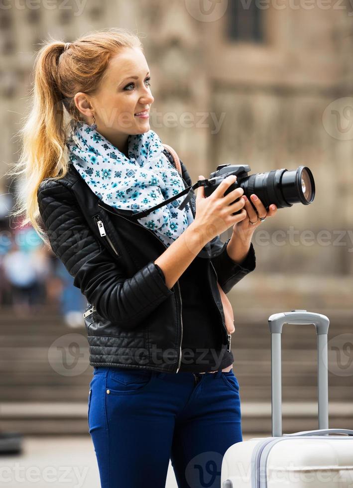 Young female traveller with camera photo