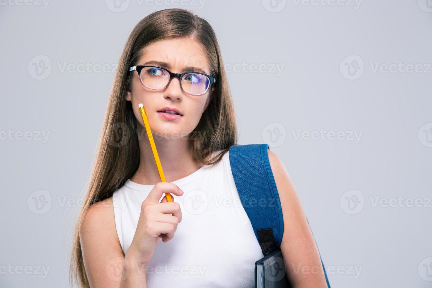 Thoughtful female teenager holding pencil photo