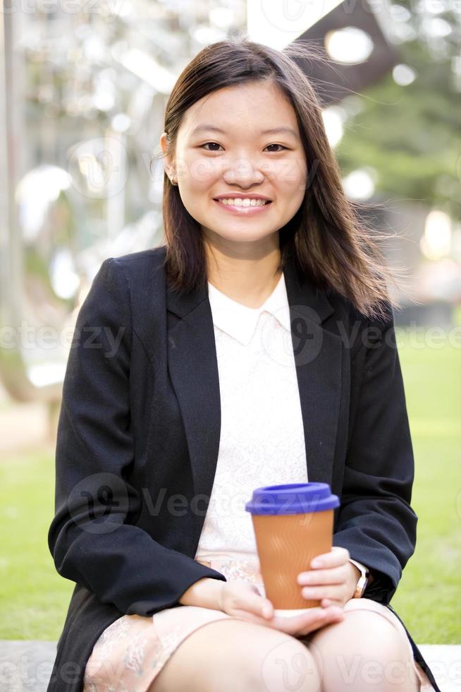 Young female Asian executive holding file photo