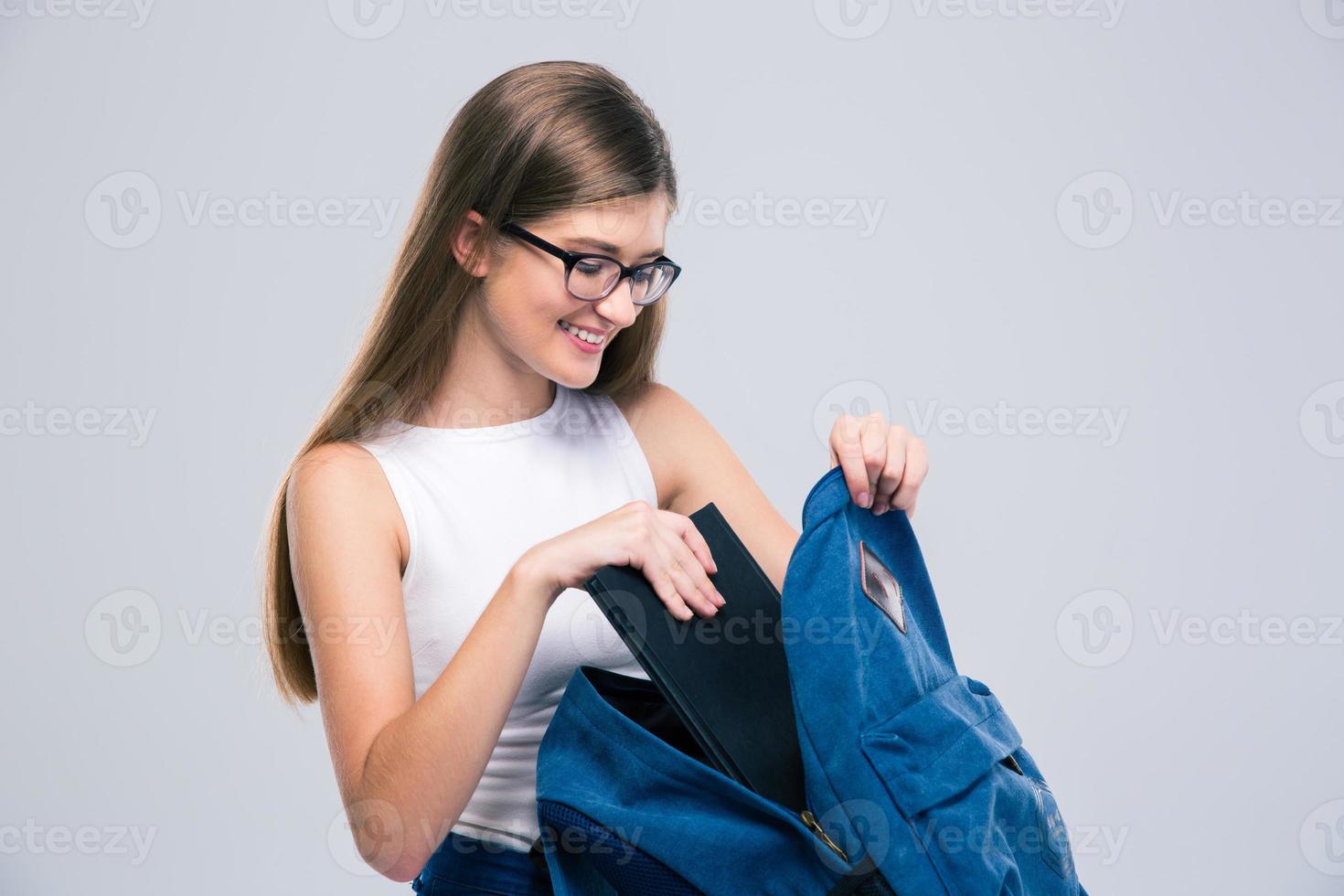 Female teenager searching something in backpack photo