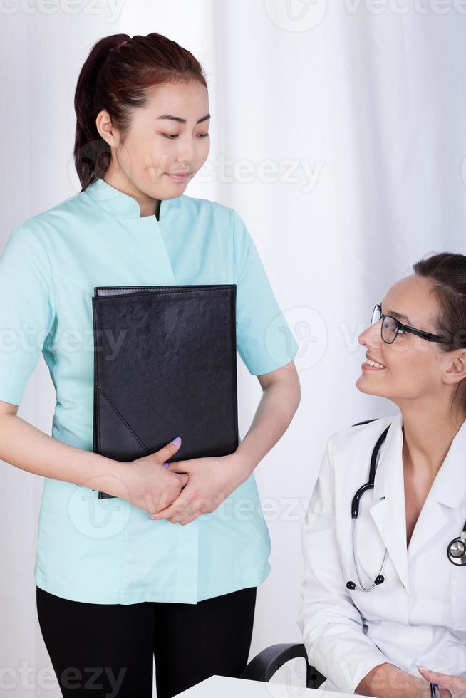 Caucasian female doctor and Asian assistant photo