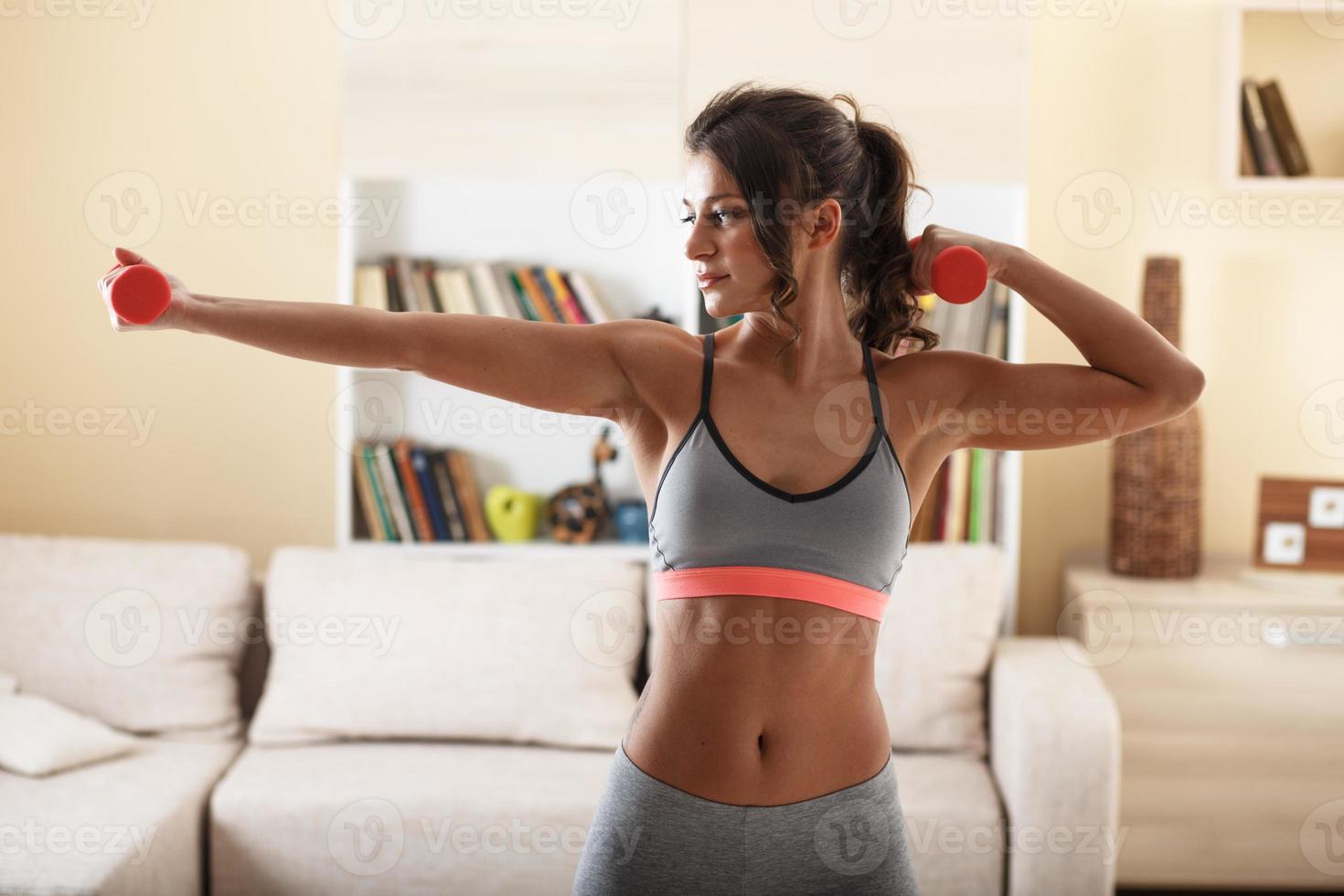 Attractive female doing exercise at home. photo