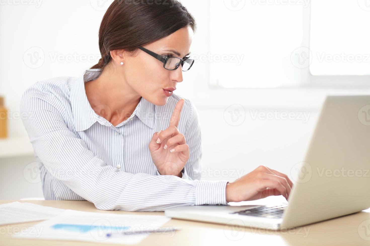 Pretty female executive using her laptop photo