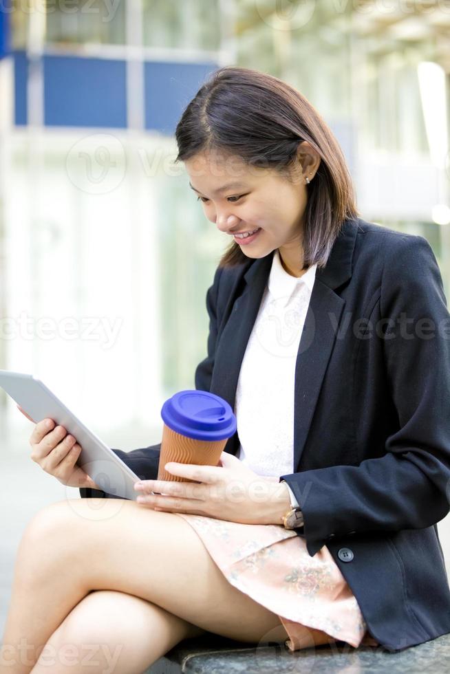 joven ejecutivo de negocios asiático femenino usando tableta foto