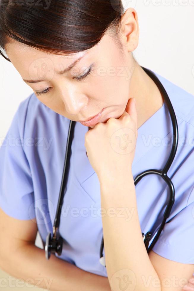 Young Japanese female doctor worries about something photo