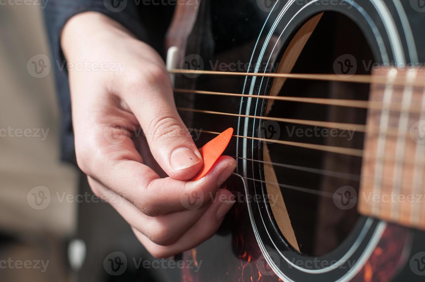 Female hand playing acoustic guitar photo