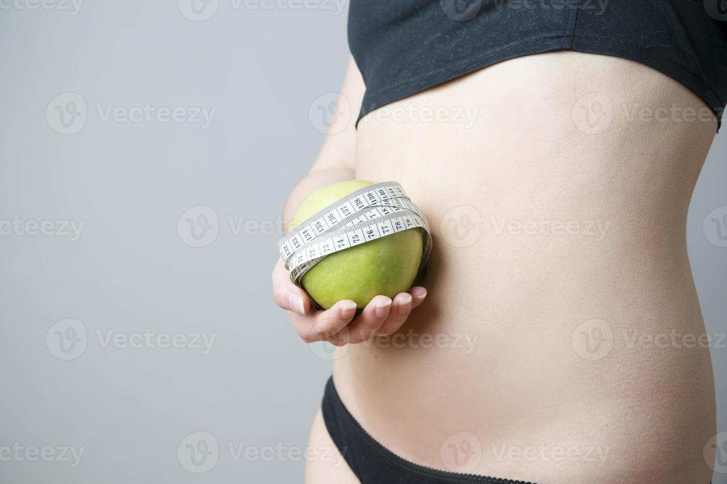 cuerpo femenino con manzana verde foto