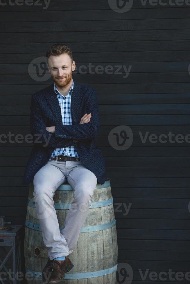hombre de chaqueta sentado en un barril foto