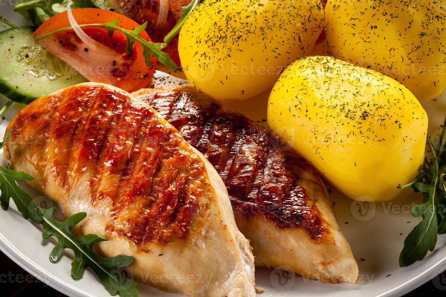 Grilled chicken fillets, boiled potatoes and vegetables photo