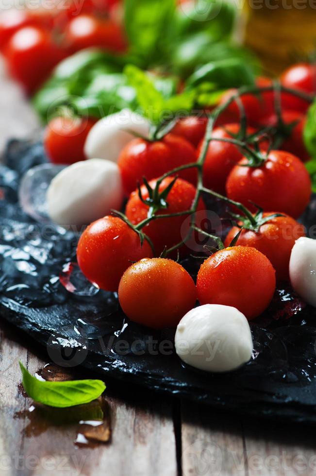 Fresh tomatoes, mozzarella and green basil photo