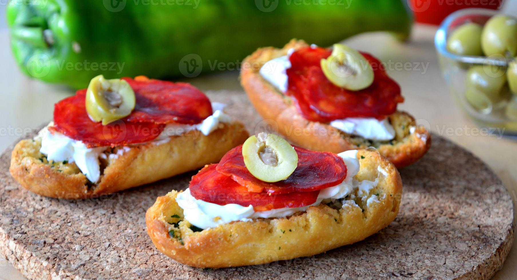 Italian bruschetta bread with salami and mozzarella on a plate photo