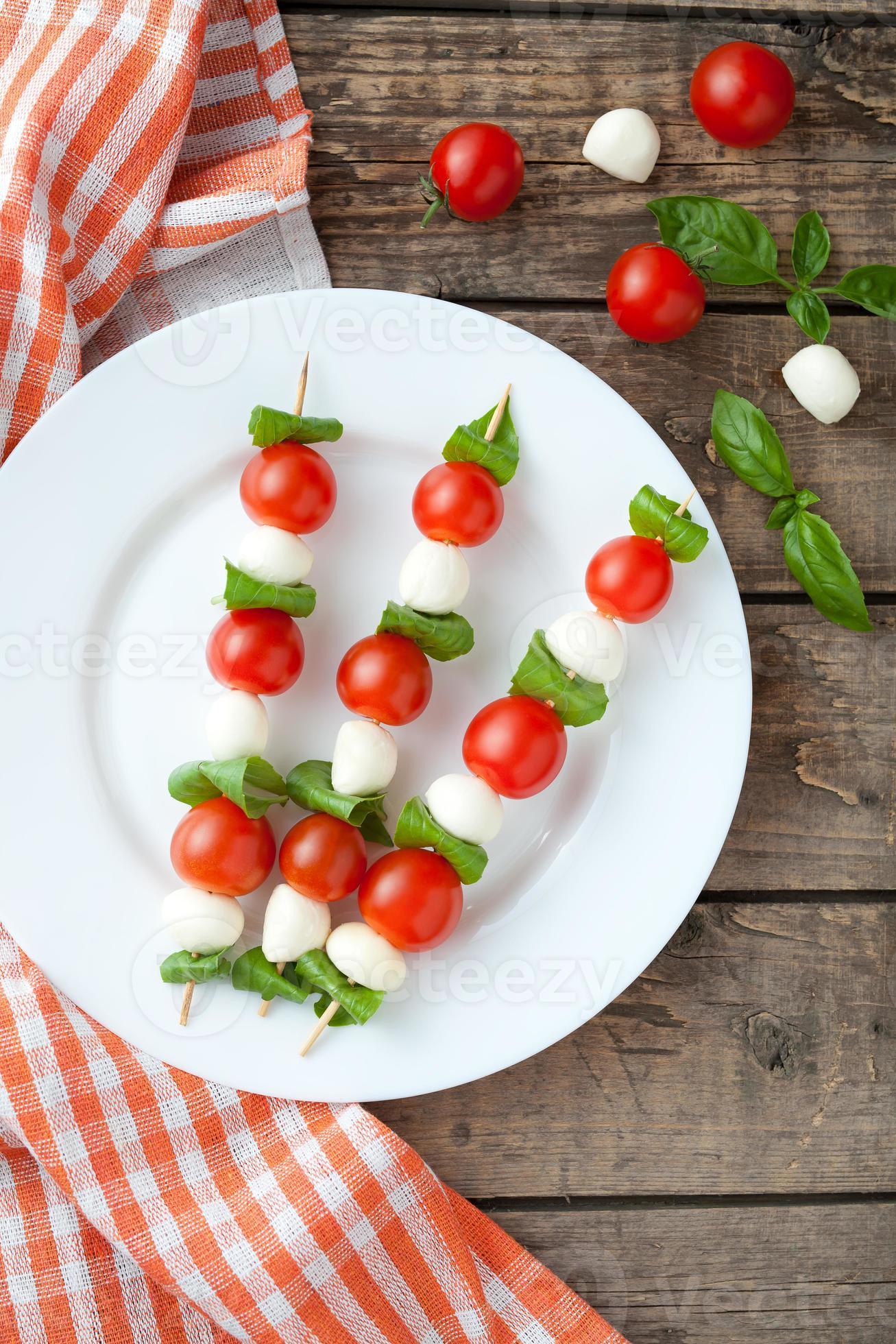 Brochetas de ensalada caprese italiana tradicional de temporada con tomate albahaca y foto