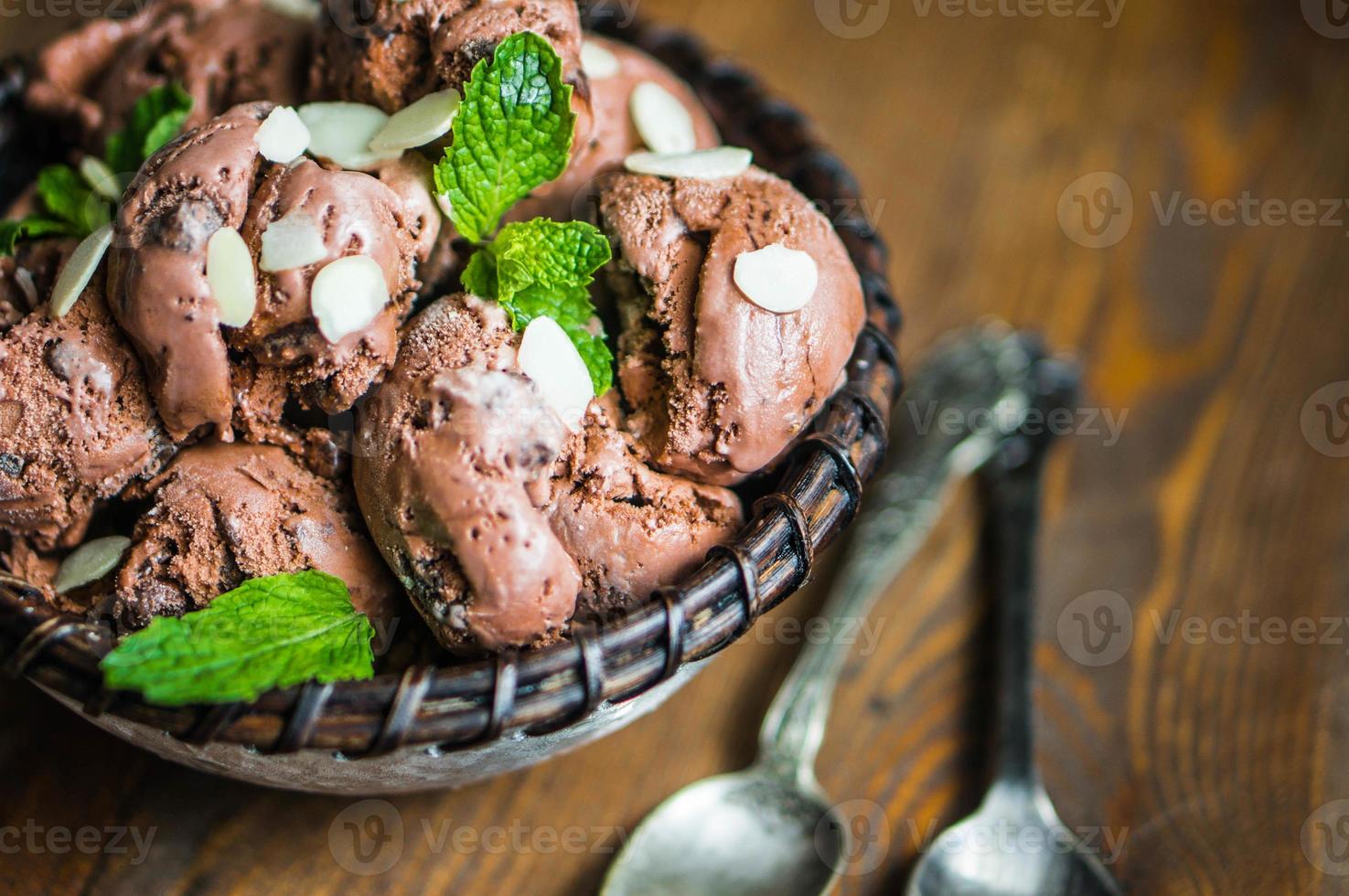 Chocolate ice cream with mint and almonds on wooden background photo
