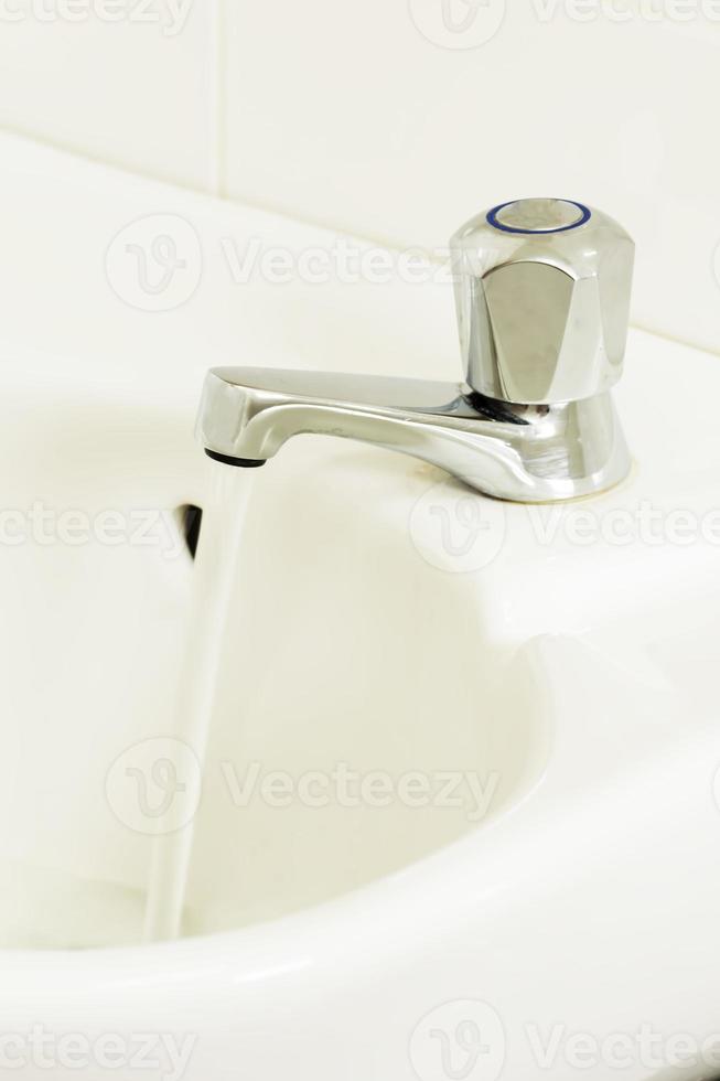 Open water tap with flowing water photo