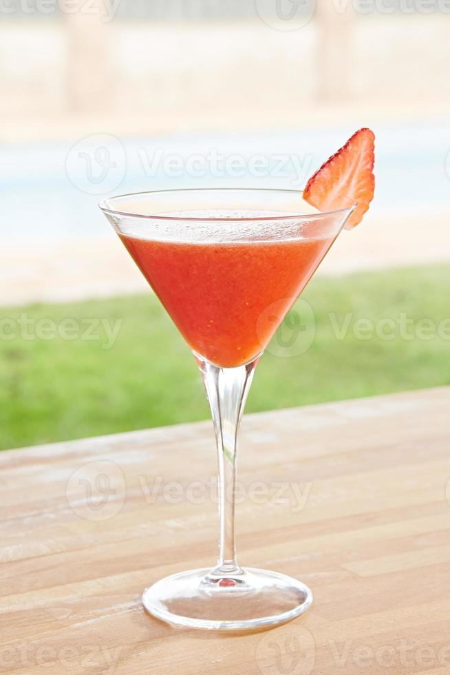 Strawberry daiquiri cocktail by a pool outdoors photo