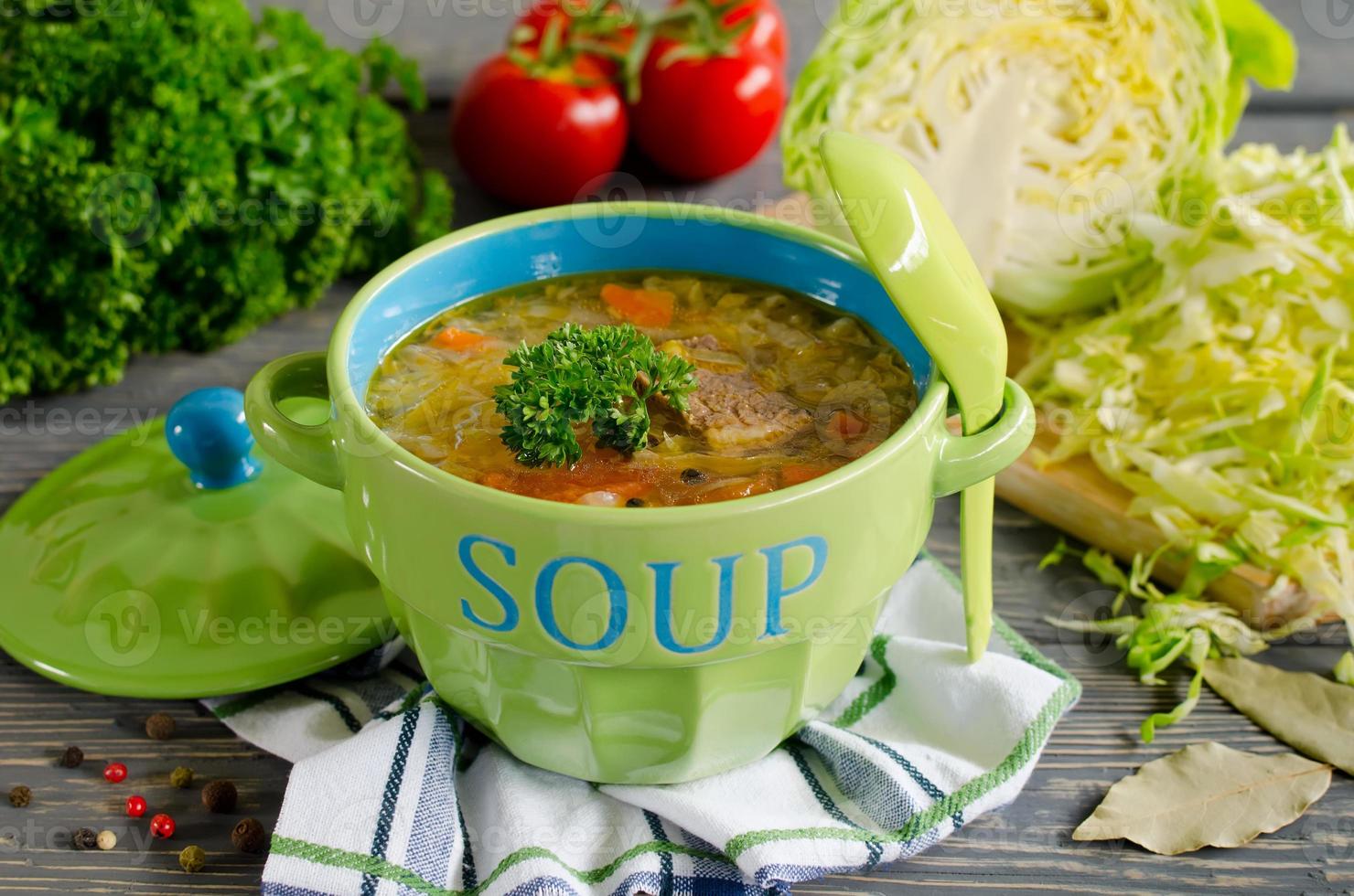 Shchi - traditional russian cabbage soup on a wooden table photo