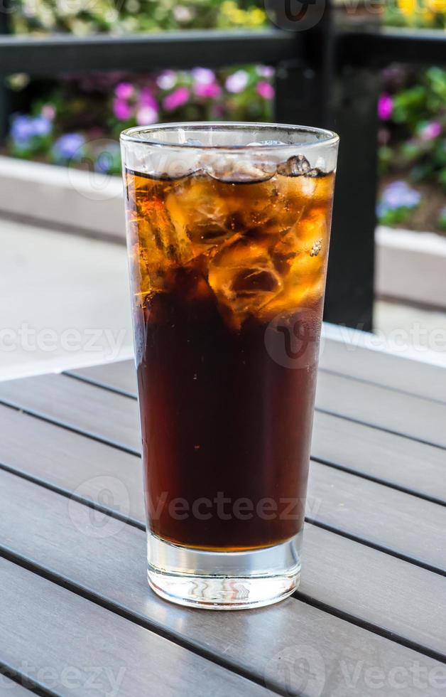 glass of cola with ice cubes photo