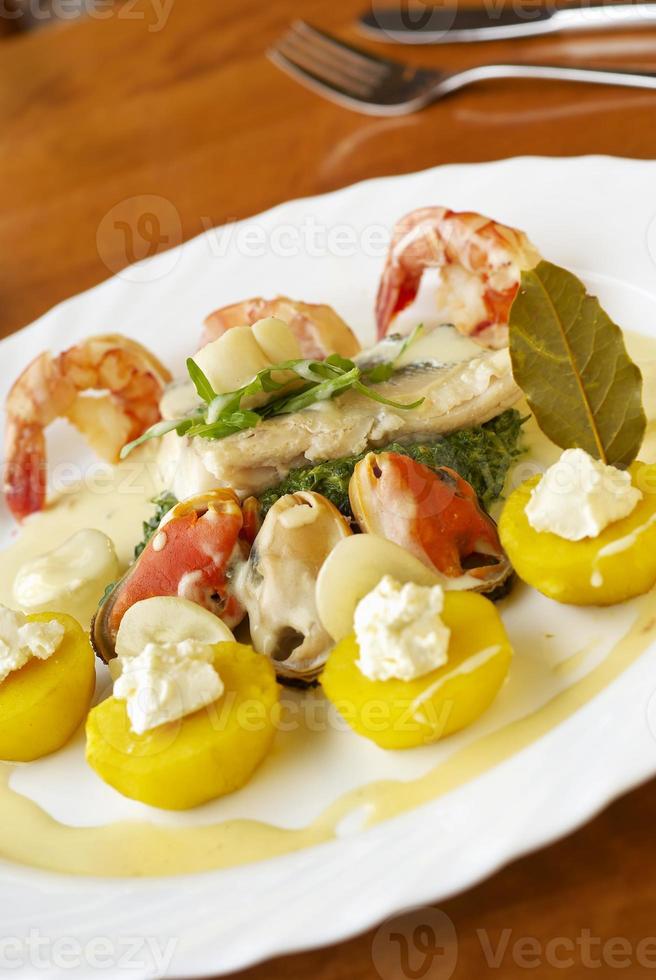Seafood with spinach, yellow potatoes and cream sauce photo