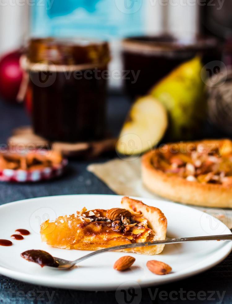 piece of apple tart on a round plate, spoon caramel photo