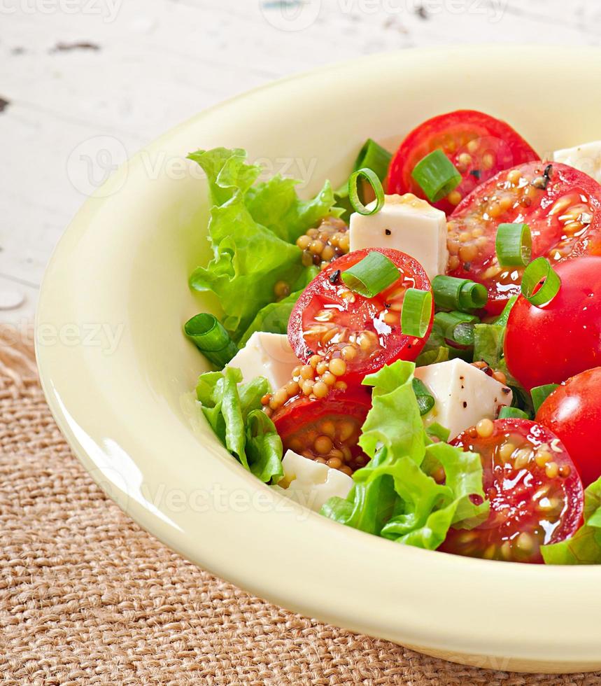 Tomato salad with lettuce, cheese and mustard and garlic dressing photo