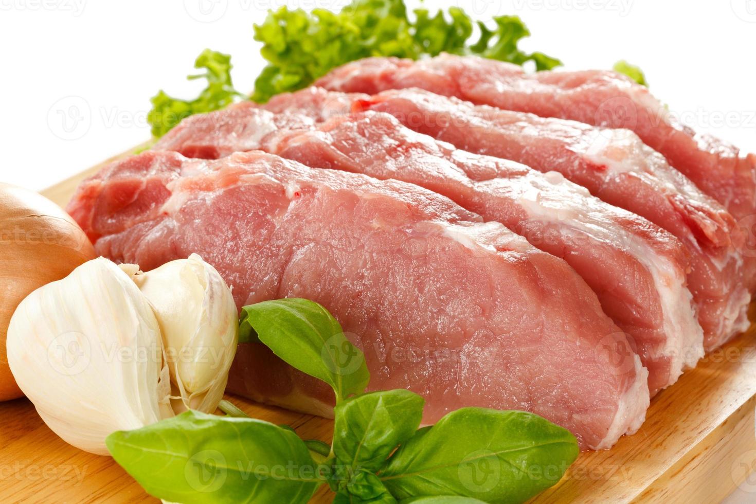 carne de cerdo cruda fresca en tabla de cortar foto