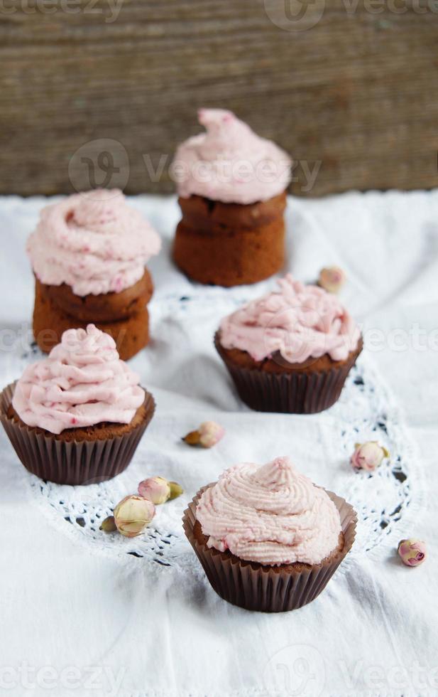 Cupcakes with cream cheese cream with raspberry and dry roses photo