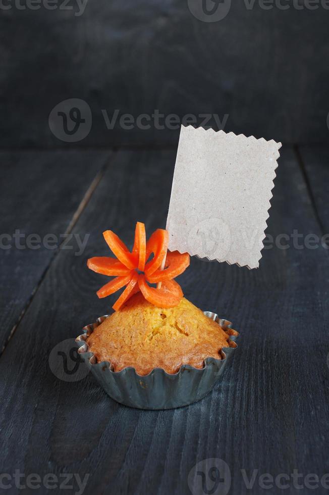 Cupcake with empty tag on the wooden table photo