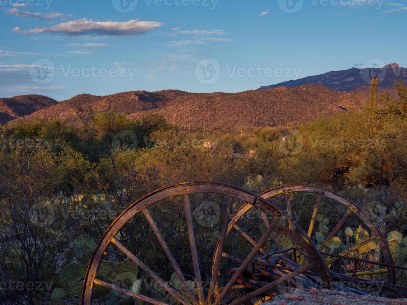 Rusted carriage weels in Arizona desert at sunset photo