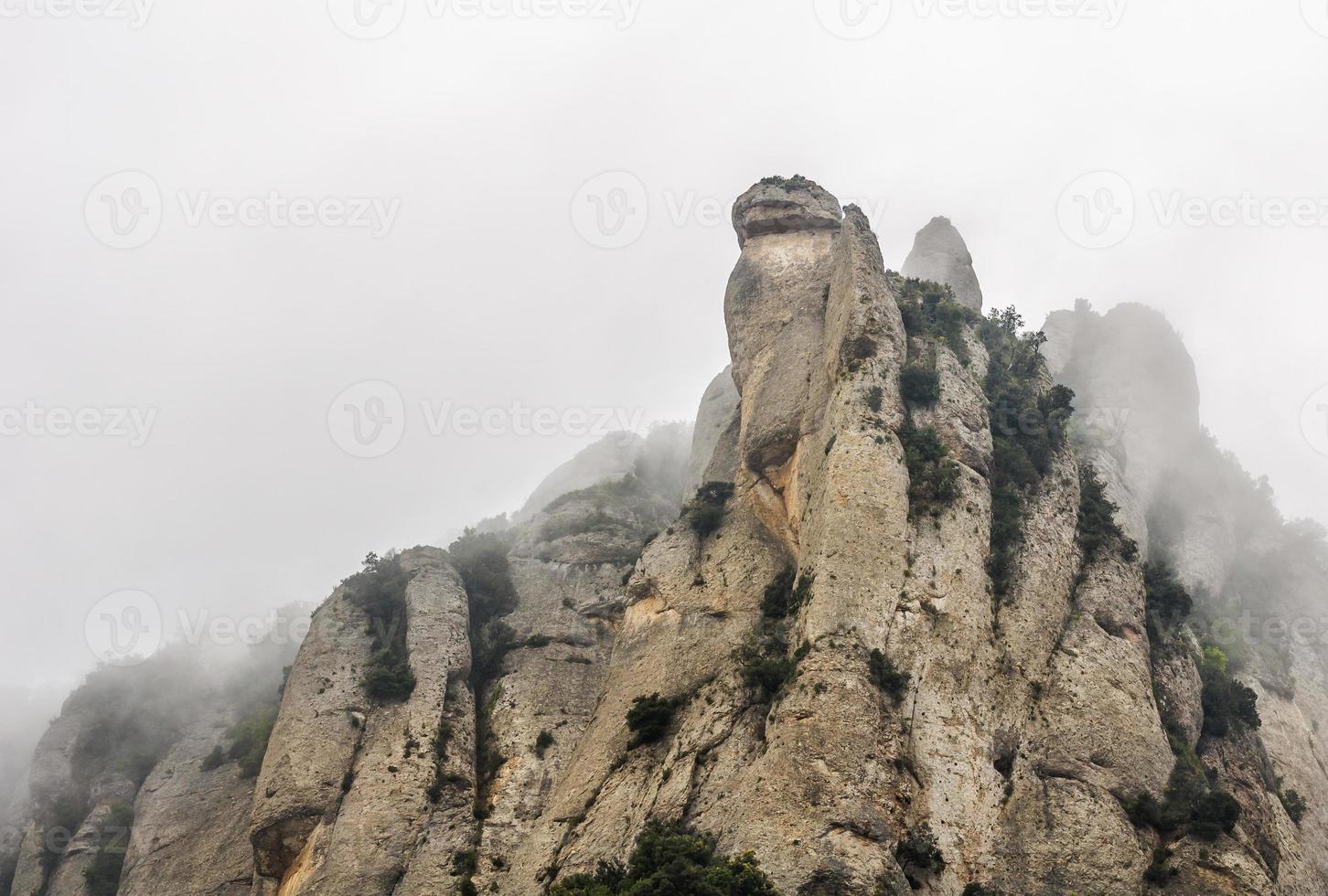 Top of mountain emerging from the fog. Montserrat, Catalonia photo