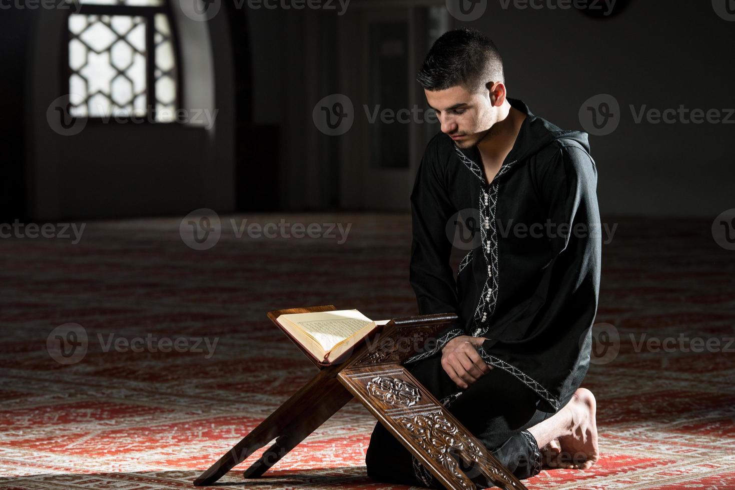 joven musulmán leyendo el Corán foto
