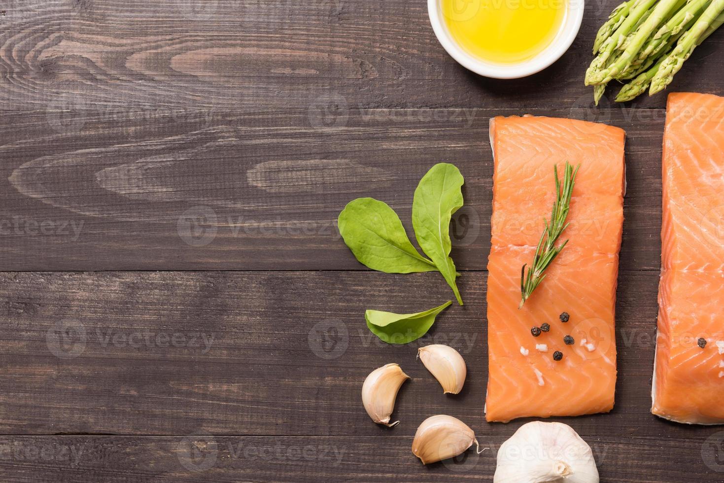 Fresh salmon fillet with spice on wooden background photo