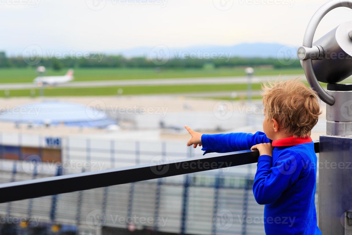 little boy looking at planes in the airport photo