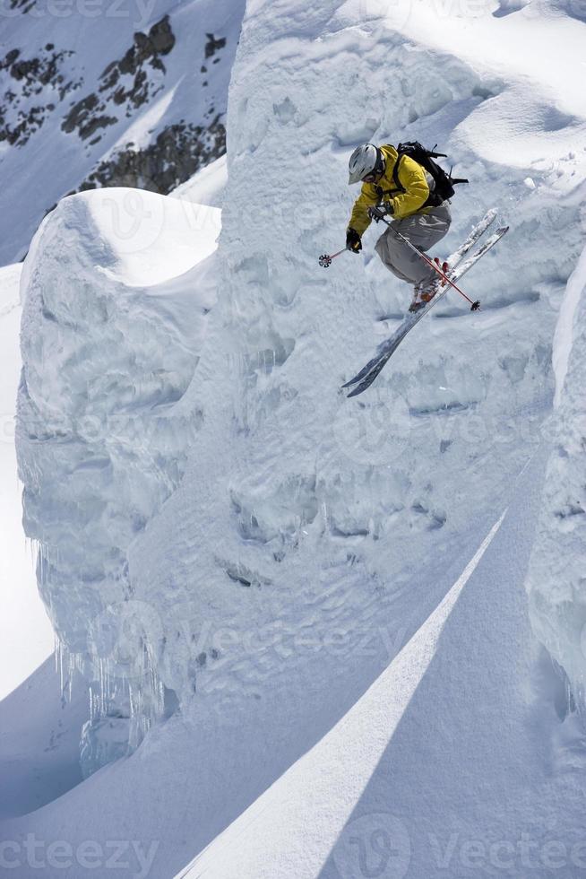 el esquiador salta desde el borde de la cresta de nieve en el glaciar. foto