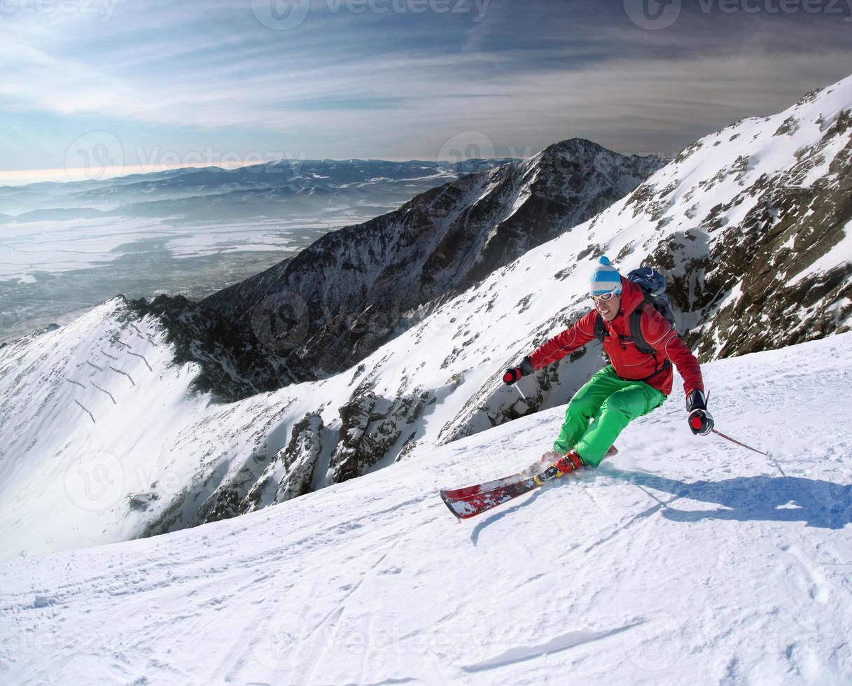 Esquiador de esquí alpino en altas montañas contra la puesta de sol foto
