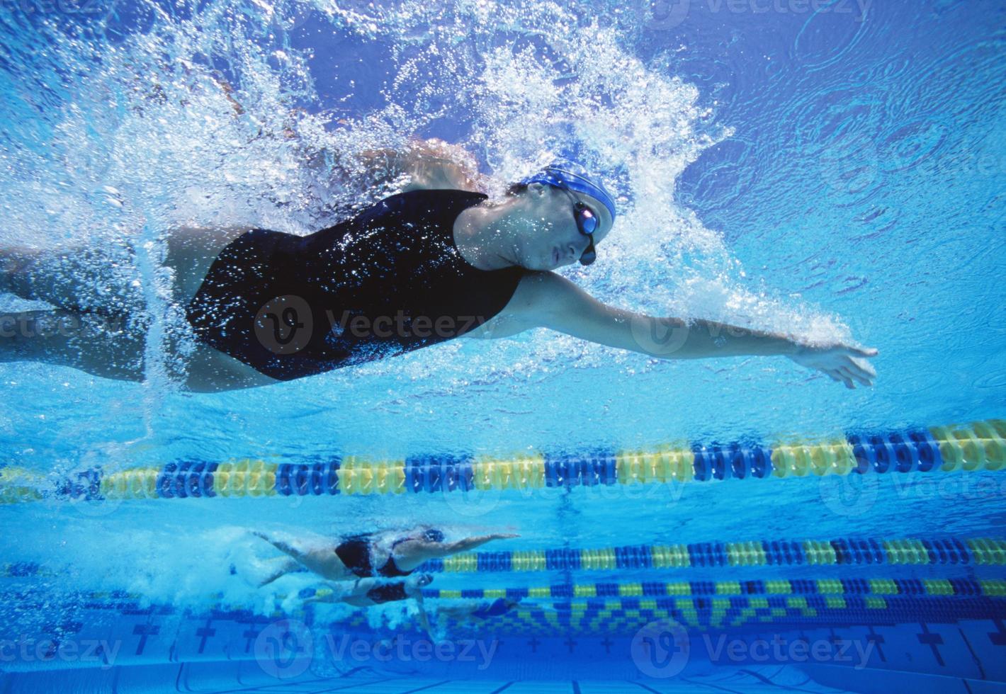 Nadadoras profesionales que nadan en la piscina foto