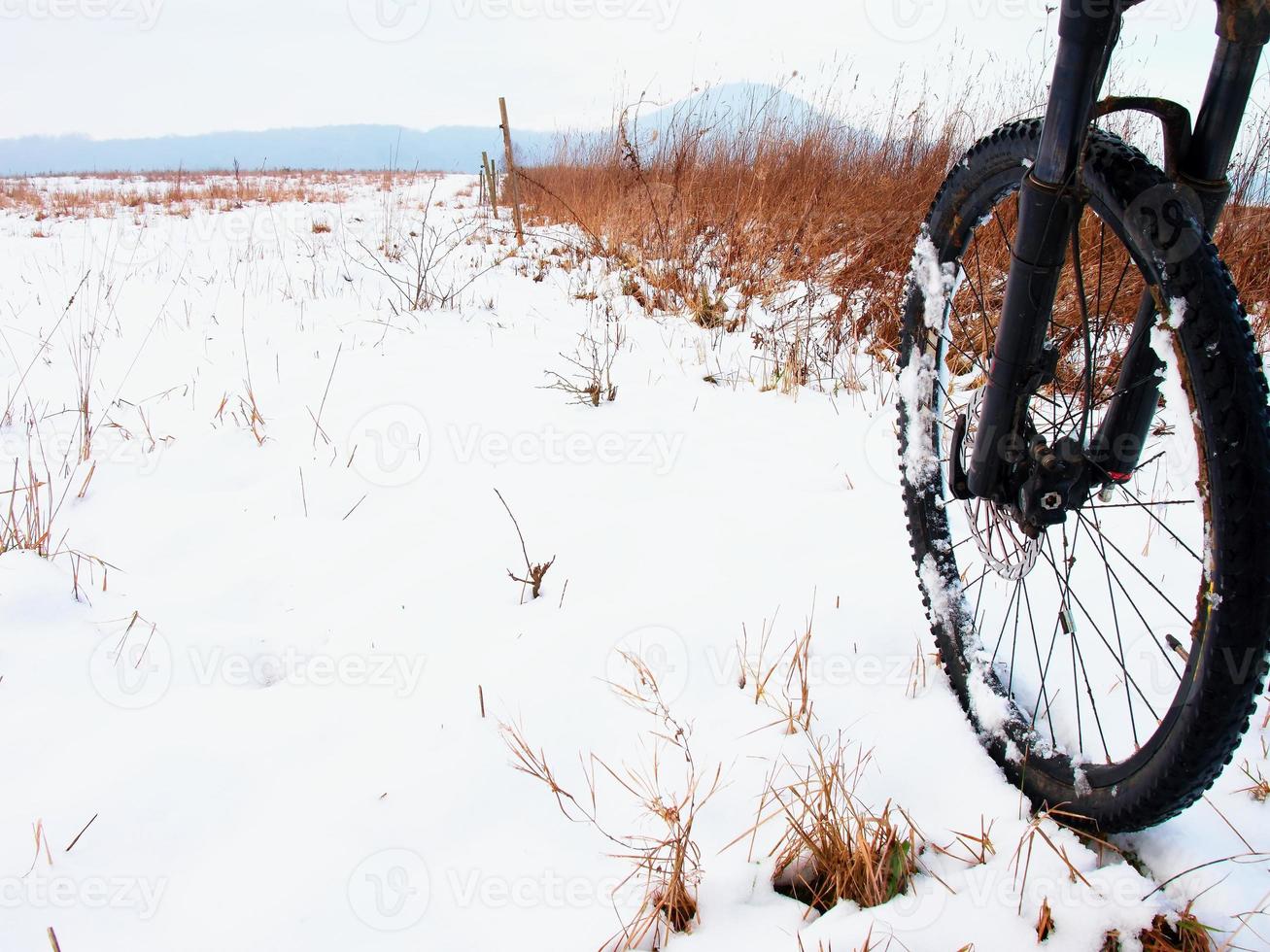 The front wheel of mountain bike in the first snow. photo