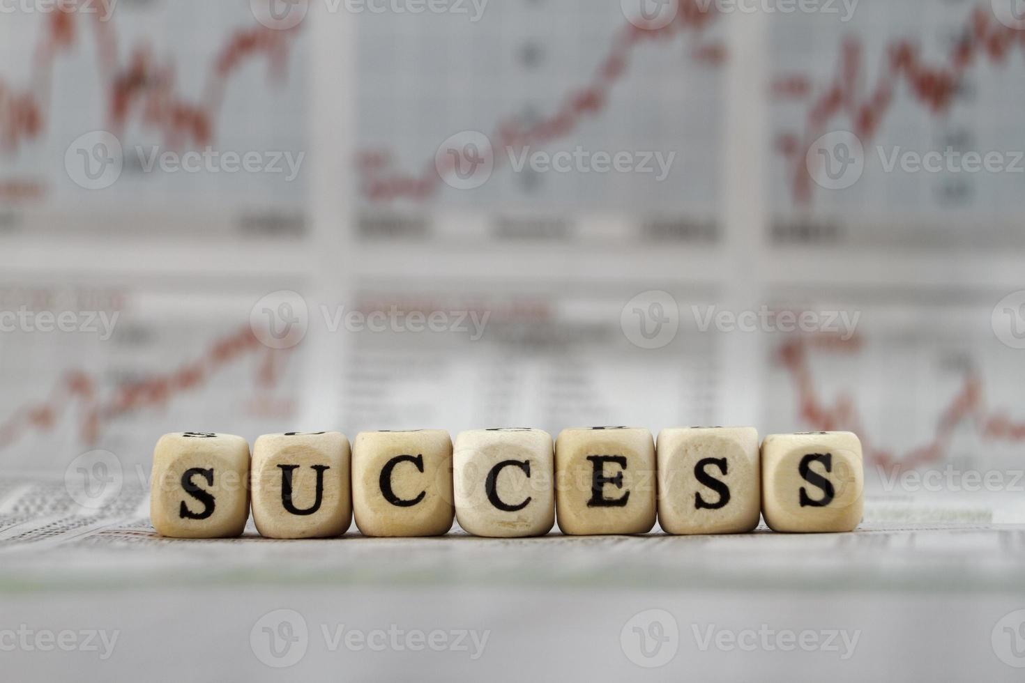 Success word built with letter cubes on newspaper background photo