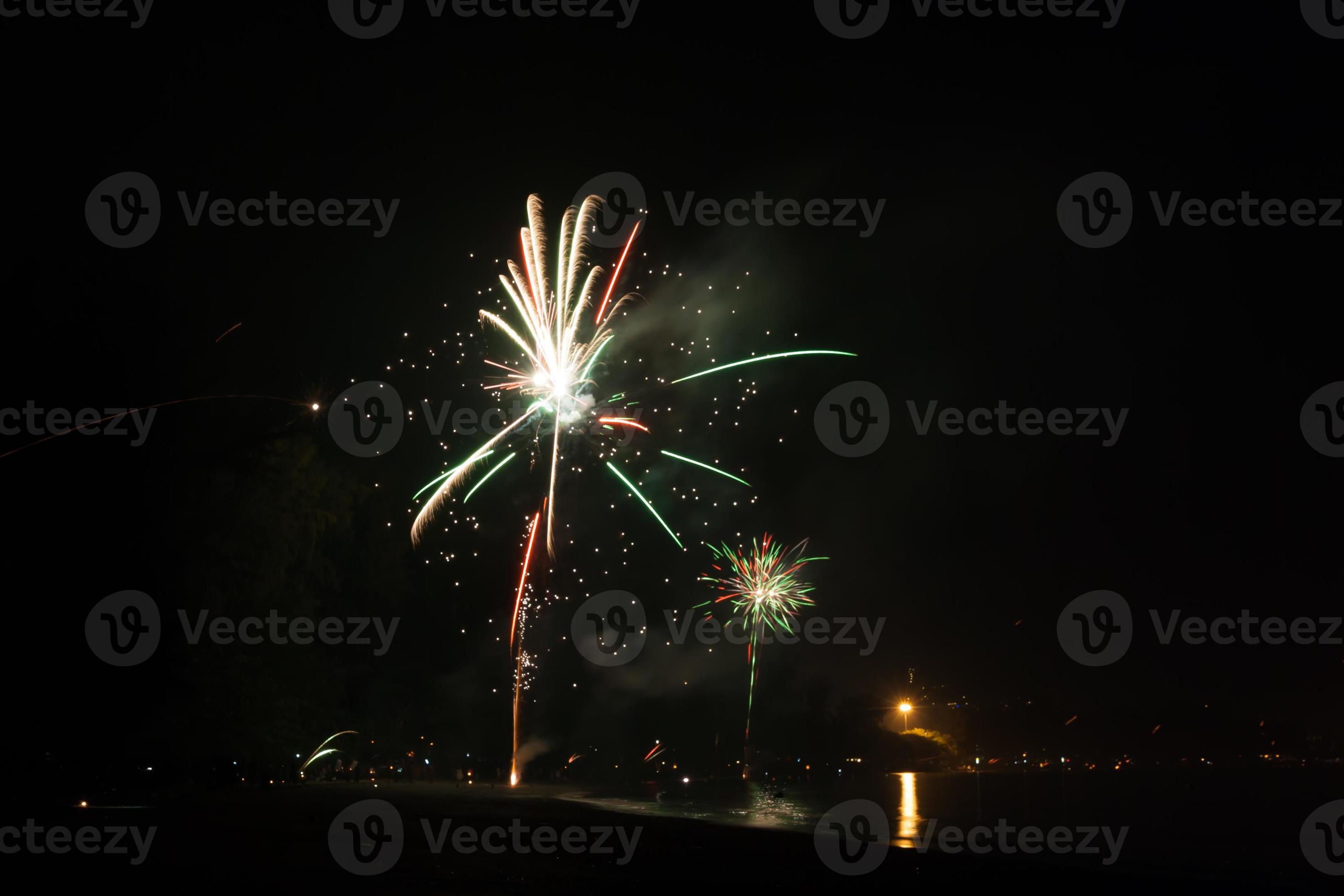 hermosos fuegos artificiales celebrando año nuevo en la playa foto
