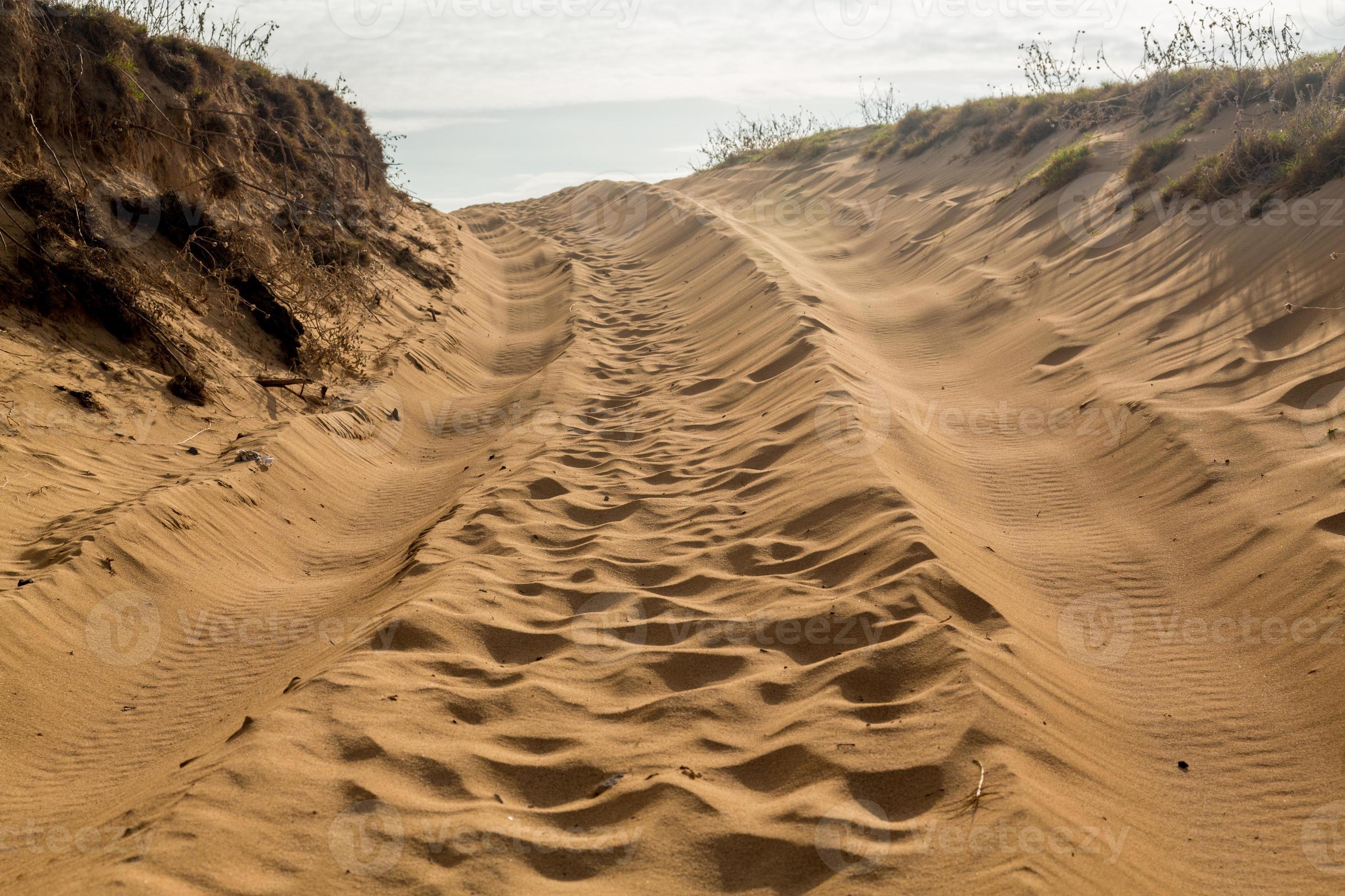Tire tracks in sand dunes over hill 794314 Stock Photo at Vecteezy