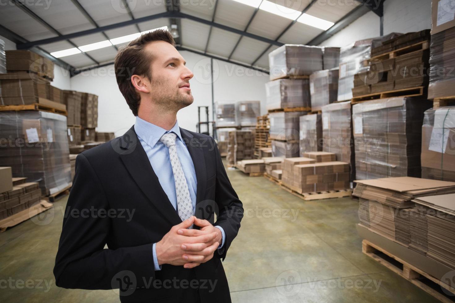 Warehouse manager standing hands together photo