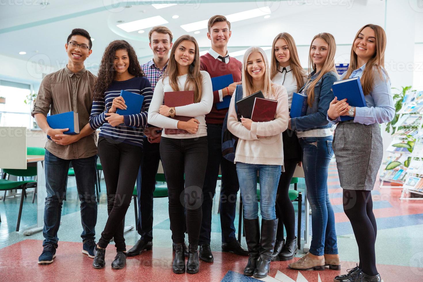 Happy students standing in classroom together photo